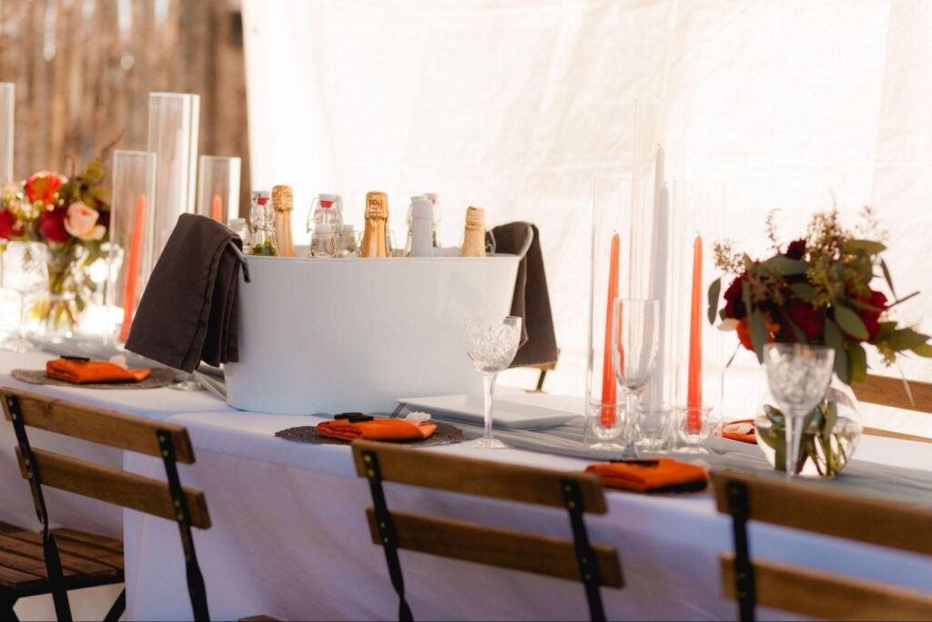 This photo features a wedding table setup with a stylish drink station, vibrant florals, and elegant tableware, highlighting the contrast in detail and coordination that can be achieved when comparing a wedding planner vs DIY wedding approach.