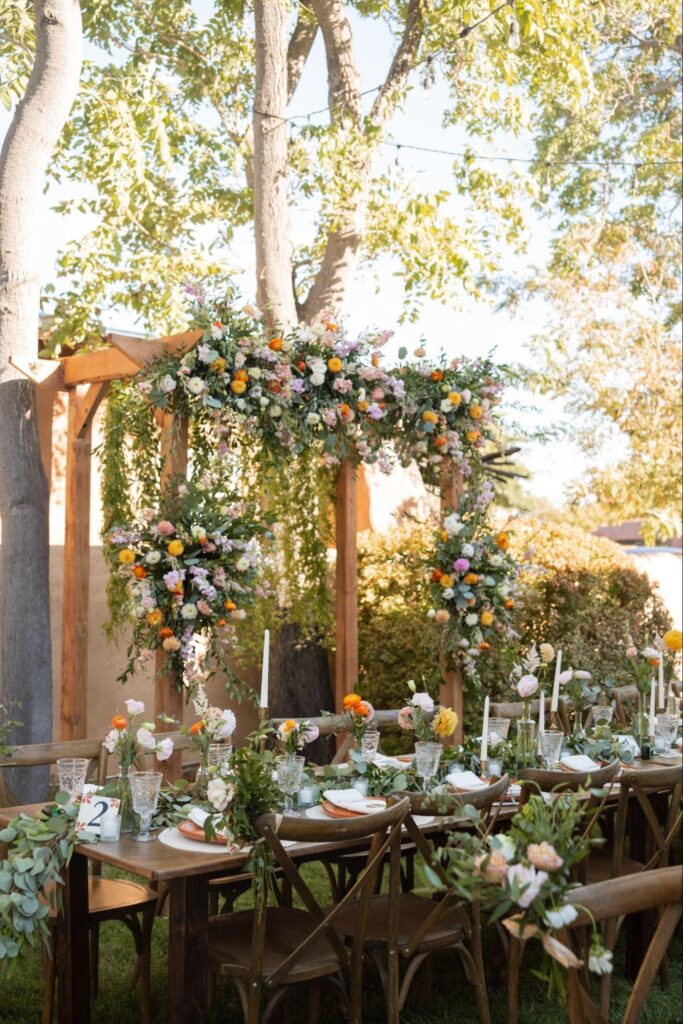 a beautifully decorated outdoor reception area with floral centerpieces and greenery.