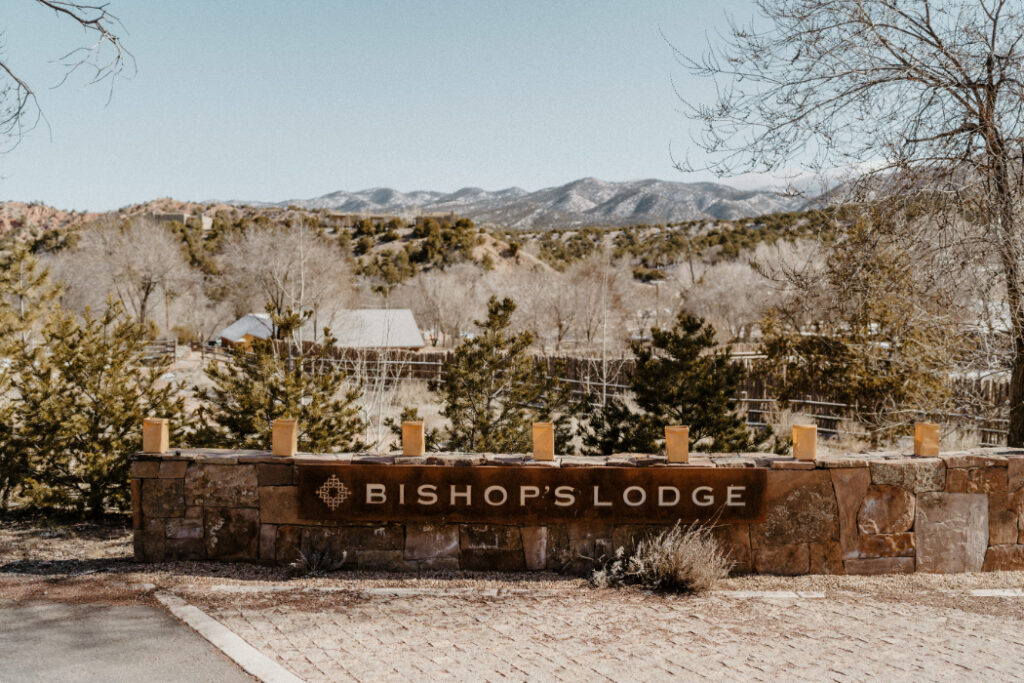 The entrance sign to Bishop's Lodge Santa Fe, NM, with mountain views.