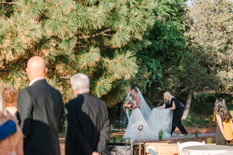 Taylor Fail, owner and lead planner of Verdeaux & Co., walks behind bride to fluff train as she walks down the aisle, one of the many tasks of a Nashville wedding planner.