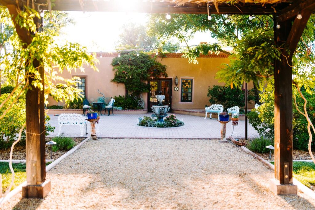 Courtyard with a central fountain, adobe-style building, and string lights, creating a cozy and inviting outdoor space.