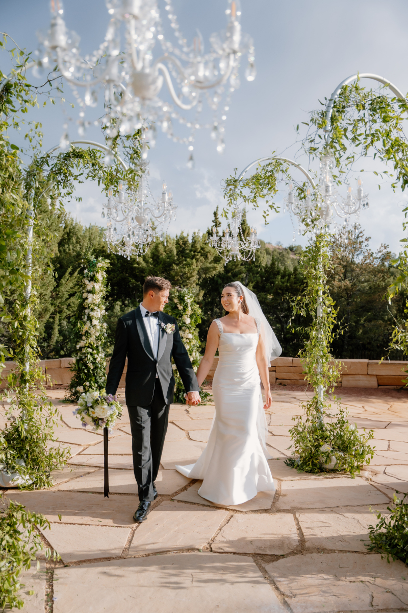 Bride and groom walk hand and hand through unique ceremony aisle that brought their different wedding themes to life.