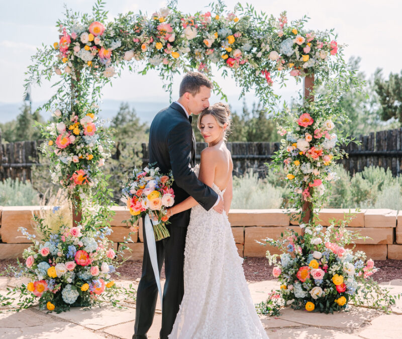 Couple enjoying the moment as they take portraits in their ceremony spot. They are completely in the moment because they searched what does a wedding planner do and hired a planner for their big day.