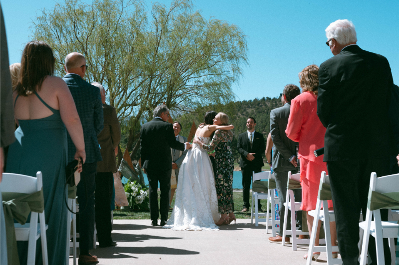 Bride hugs mother at the end of the aisle of her wedding at Inn of the Mountain Gods.