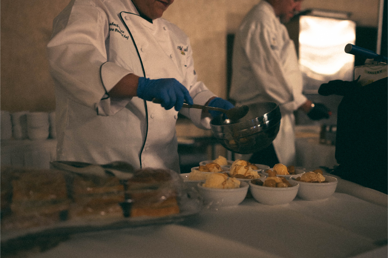 Chef prepares bananas foster for wedding reception dessert.