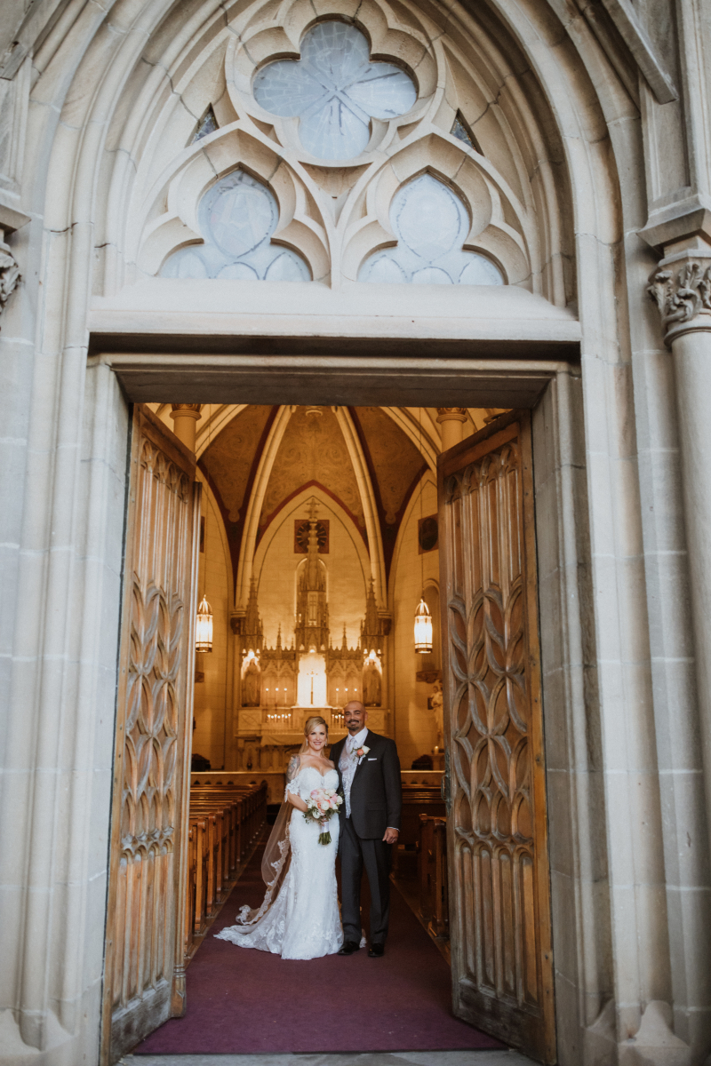 Bride and groom pose together in Loretto Chapel.