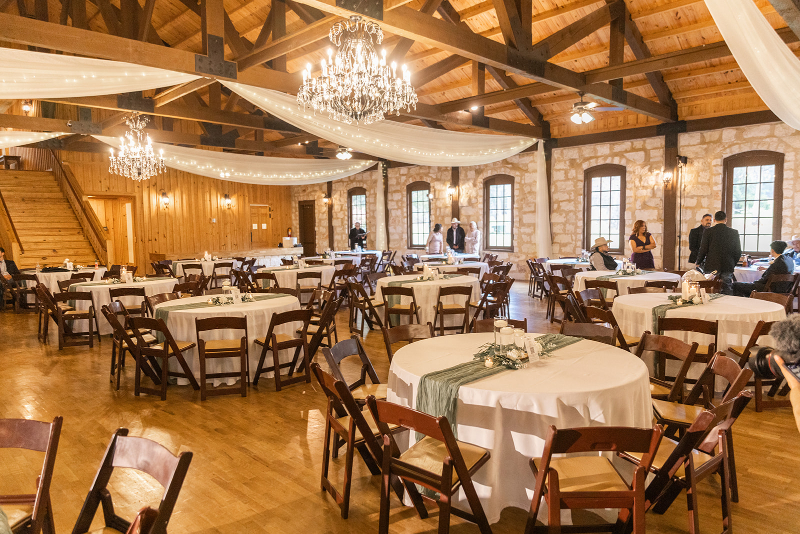 Reception hall decorated by Tennessee wedding planner team, featuring white tablecloths and sage details.