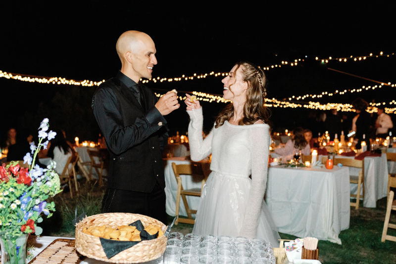 Bride and groom feed each other during their non-traditional nuptials.
